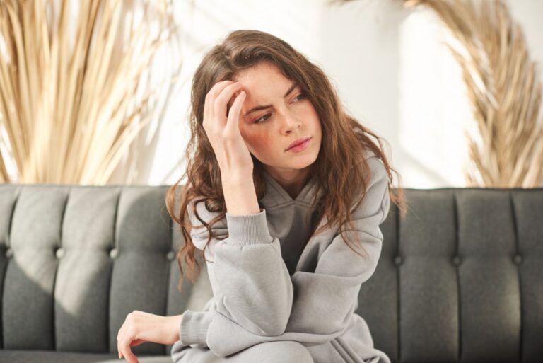 young woman sitting on the couch and thinking