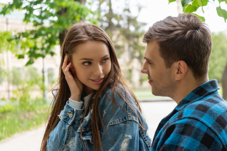 pretty woman touching hair while flirting with a man