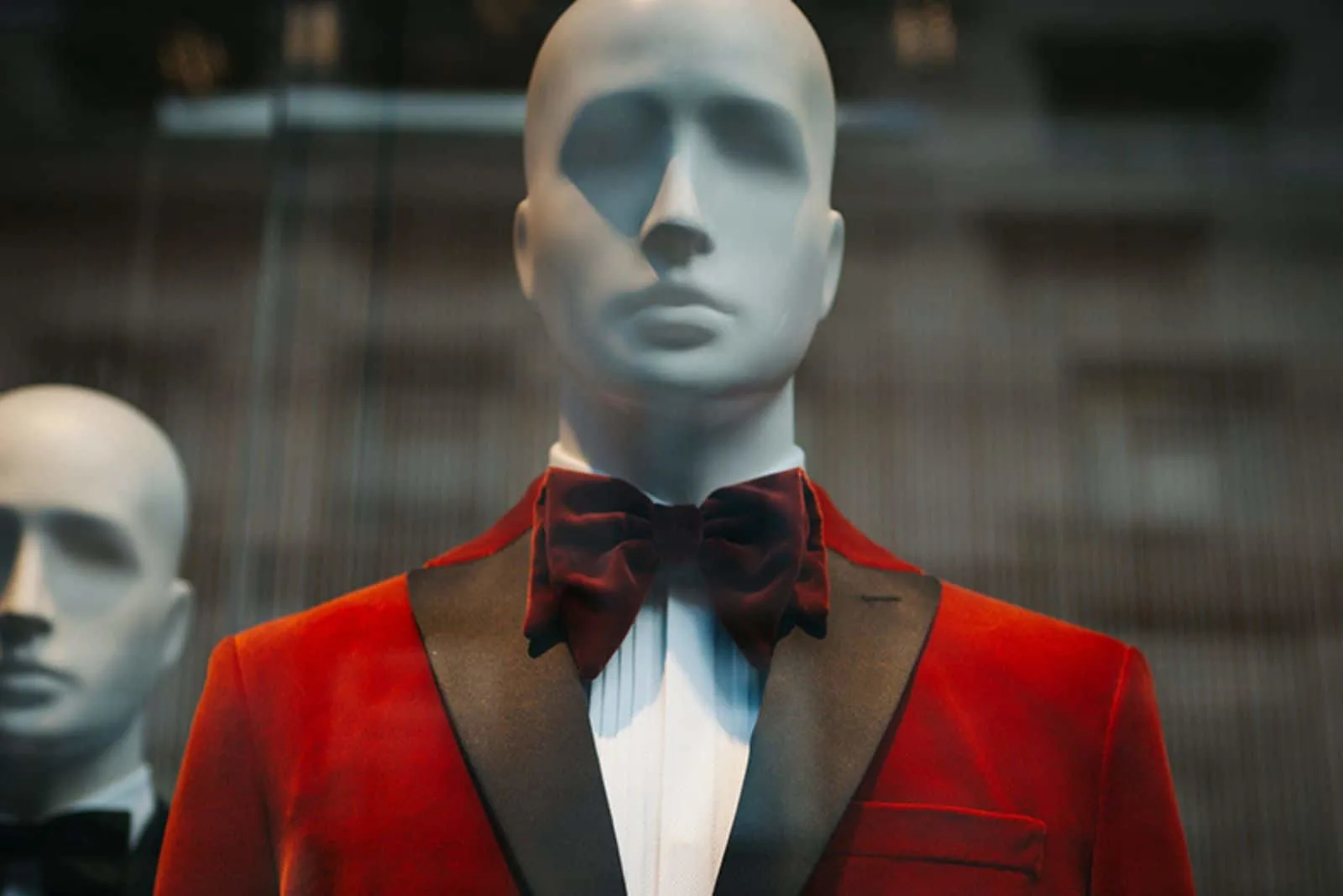 a doll in a window dressed in a red suit