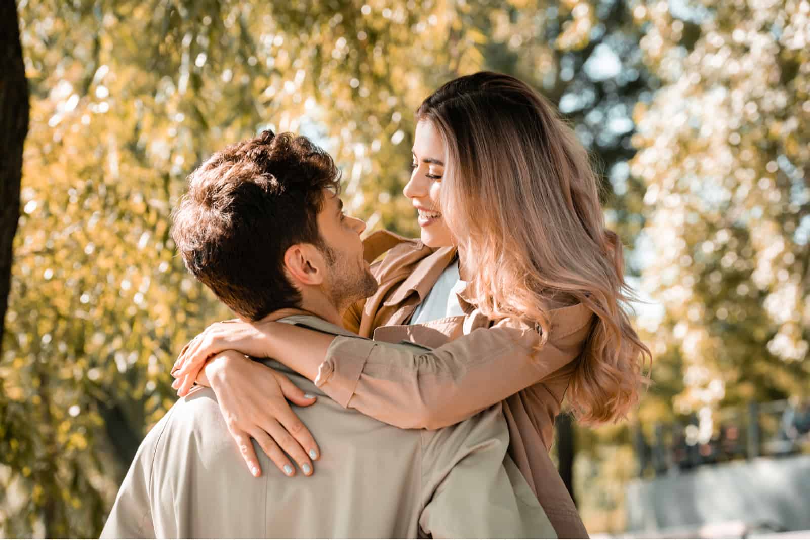woman hugs her boyfriend in autumn park