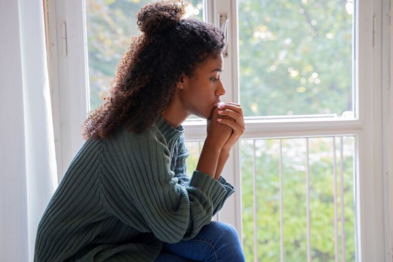 sad woman sitting by the window
