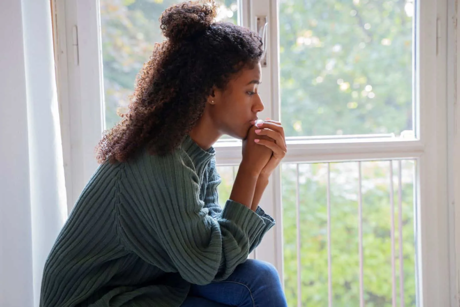sad woman sitting by the window