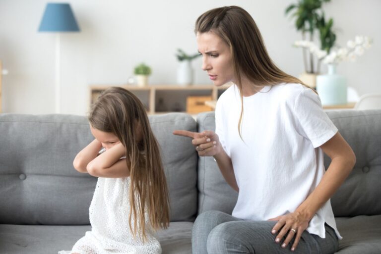 angry mother talking to daughter on the couch