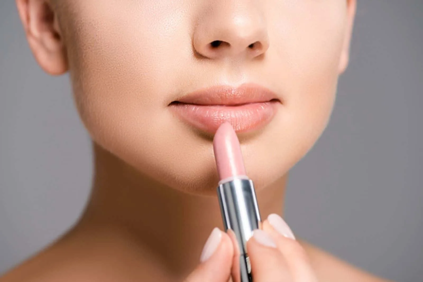 _woman applying nude lipstick