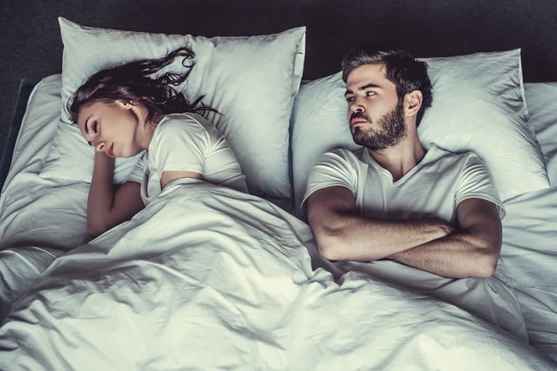 Hombre y mujer tumbados en la cama