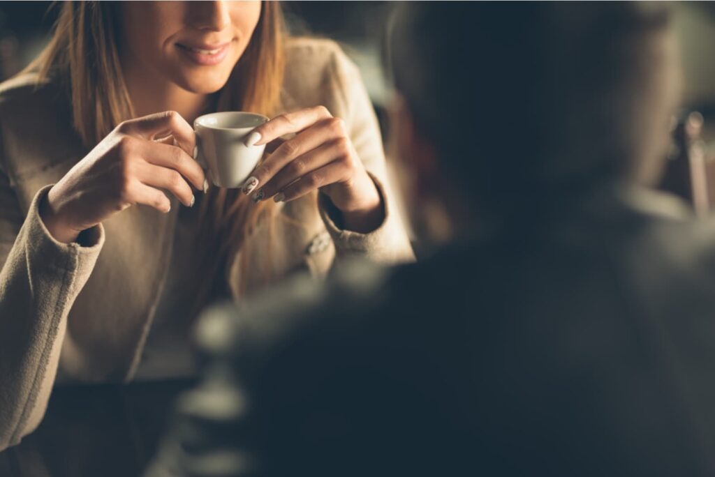mujer bebiendo café en una cita con el hombre