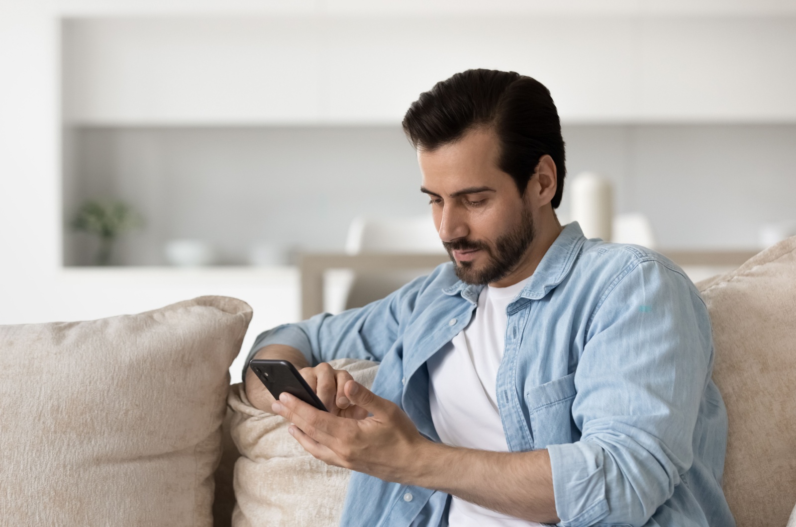 man sitting on couch texting