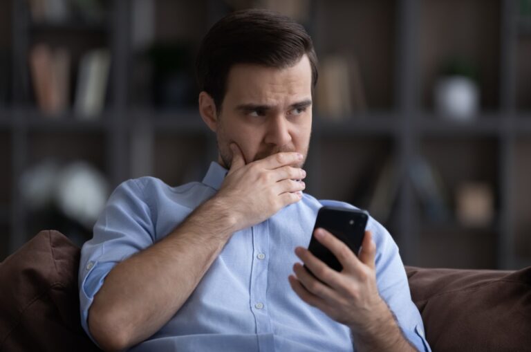 hombre preocupado sosteniendo su teléfono