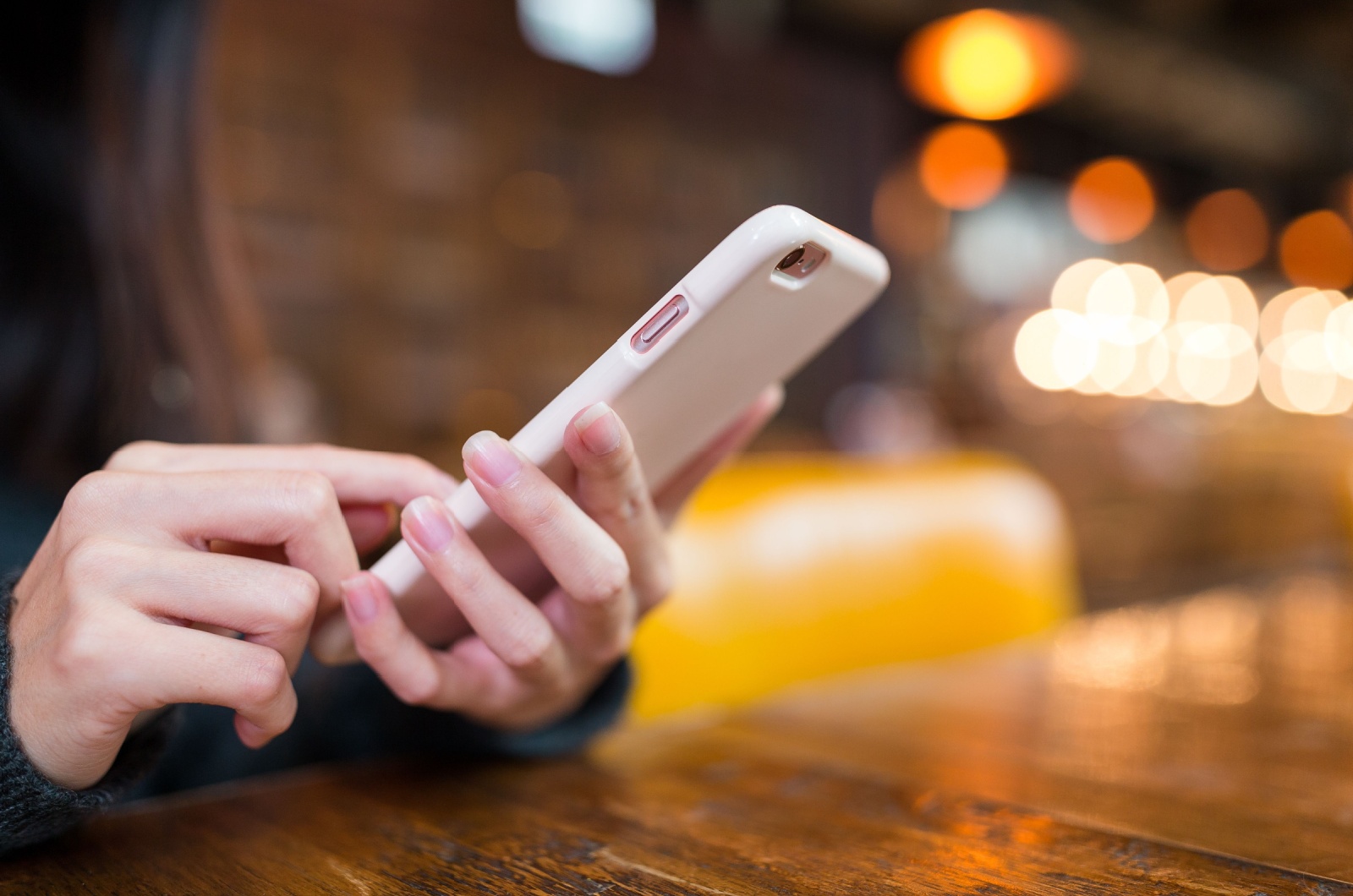 Mulher a enviar mensagens de texto para o telemóvel num café