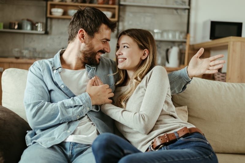 happy couple holding hands on couch