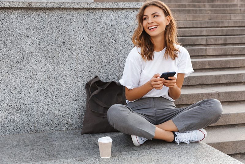 mujer feliz escribiendo al aire libre