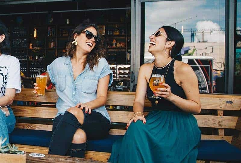 two friends laughing at the bar