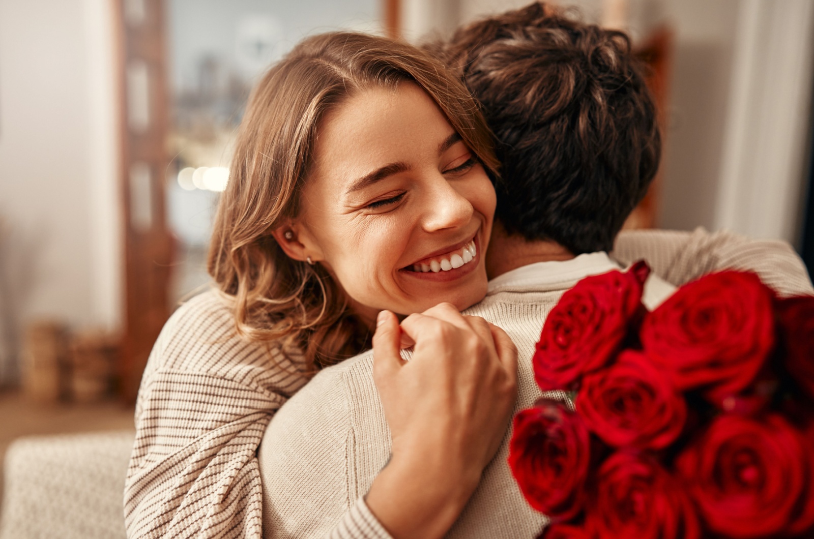 woman holding roses and hugging a boyfriend