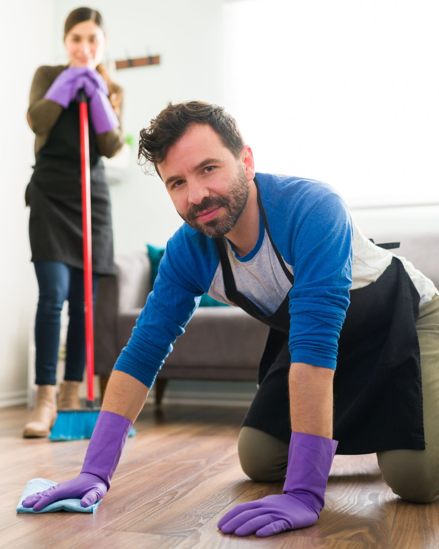 woman looking at man cleaning the floor