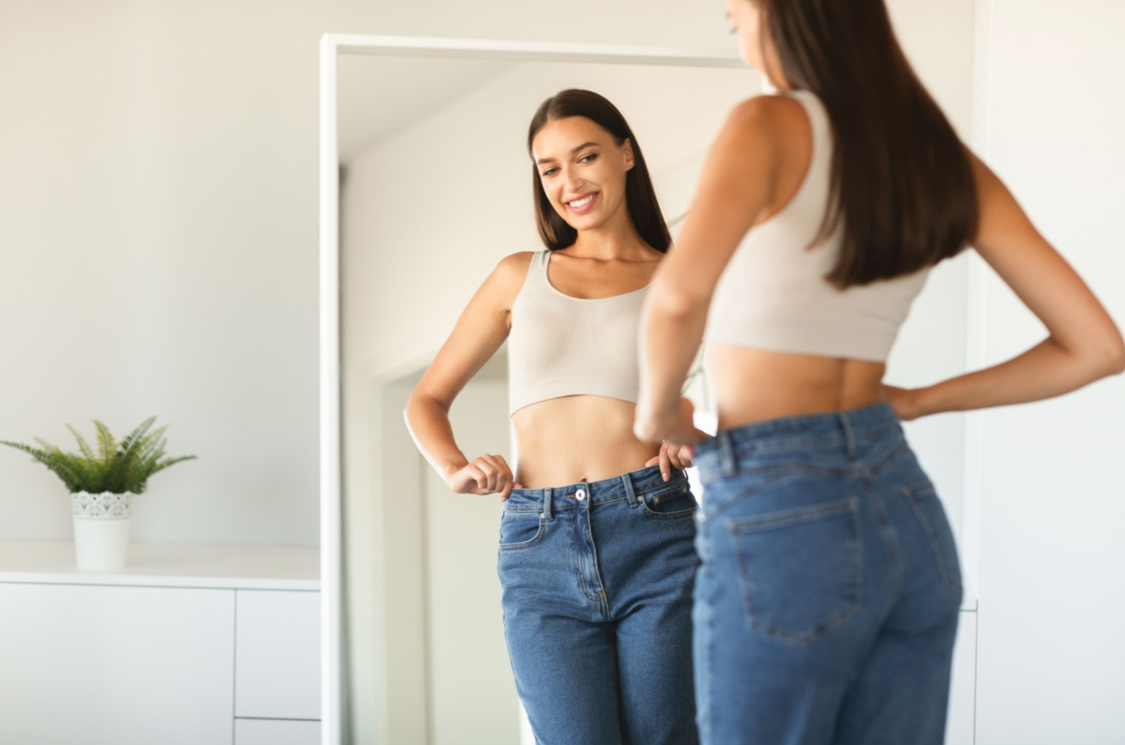 woman smiling to her reflection in mirror