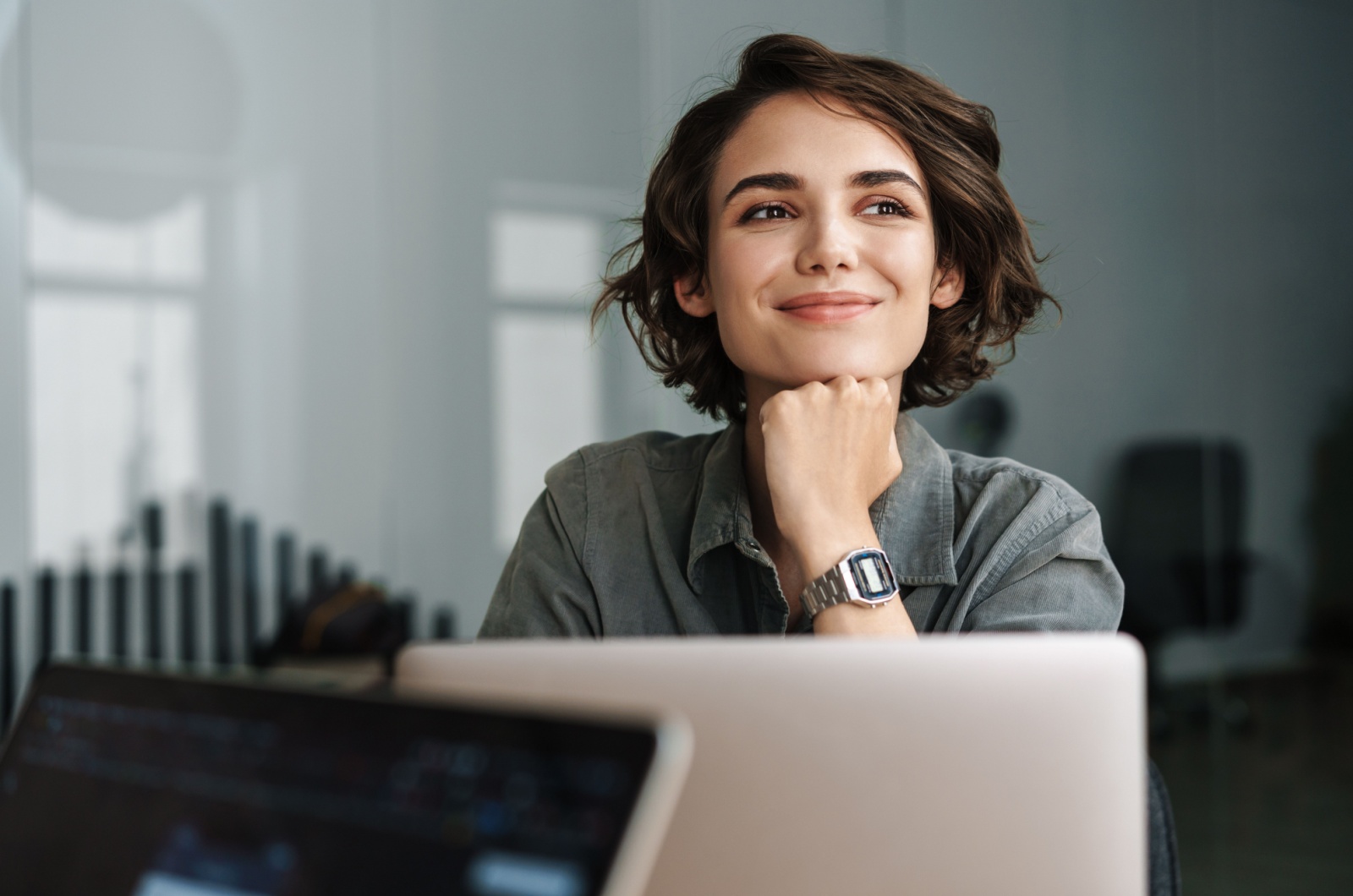 donna che sorride mentre lavora con il computer portatile in ufficio