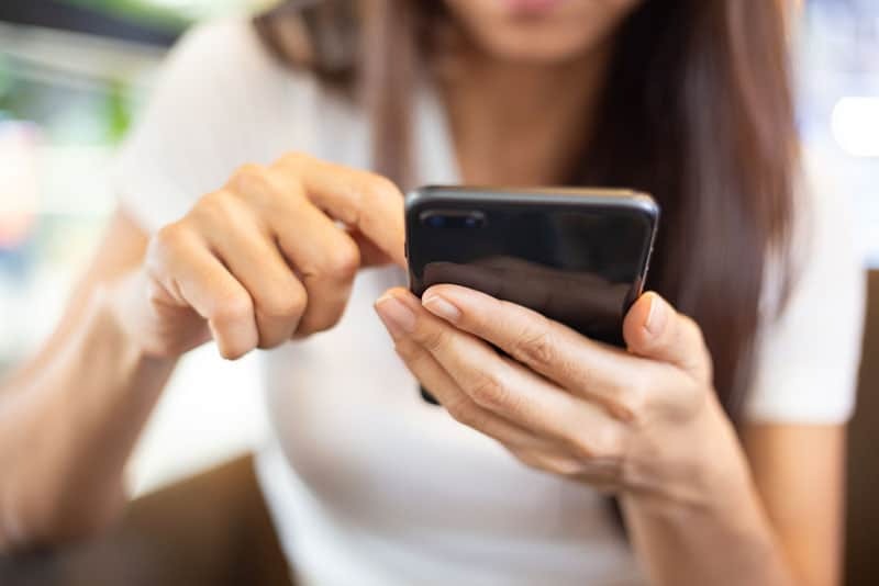 woman typing on phone