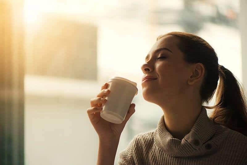 jovem mulher a saborear o café