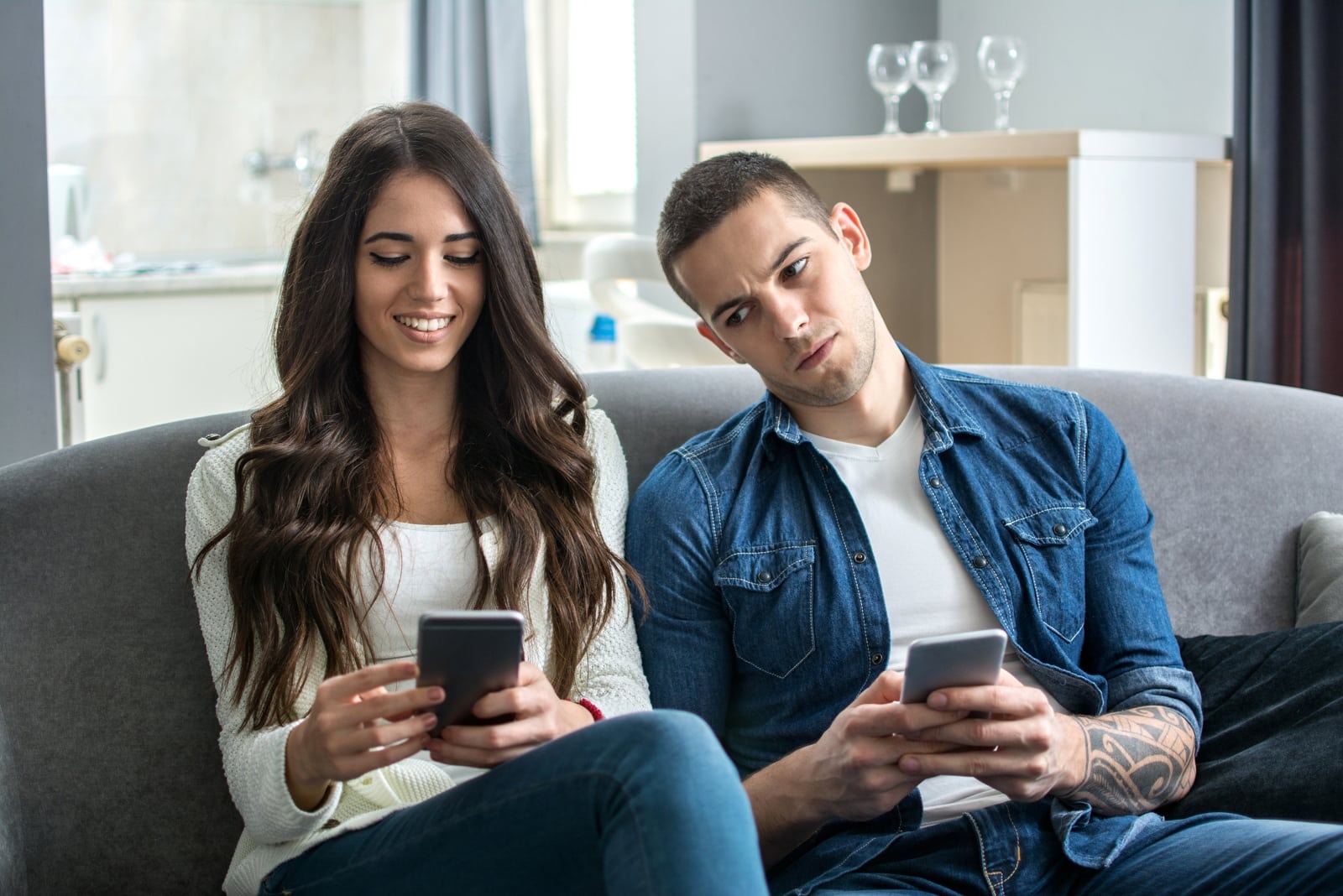 um homem a espreitar o telemóvel de uma mulher