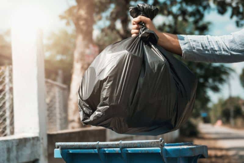 un hombre arrojando basura