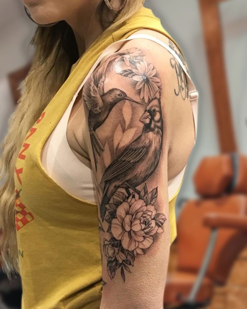 tatuagem de manga em preto com pássaros e flores