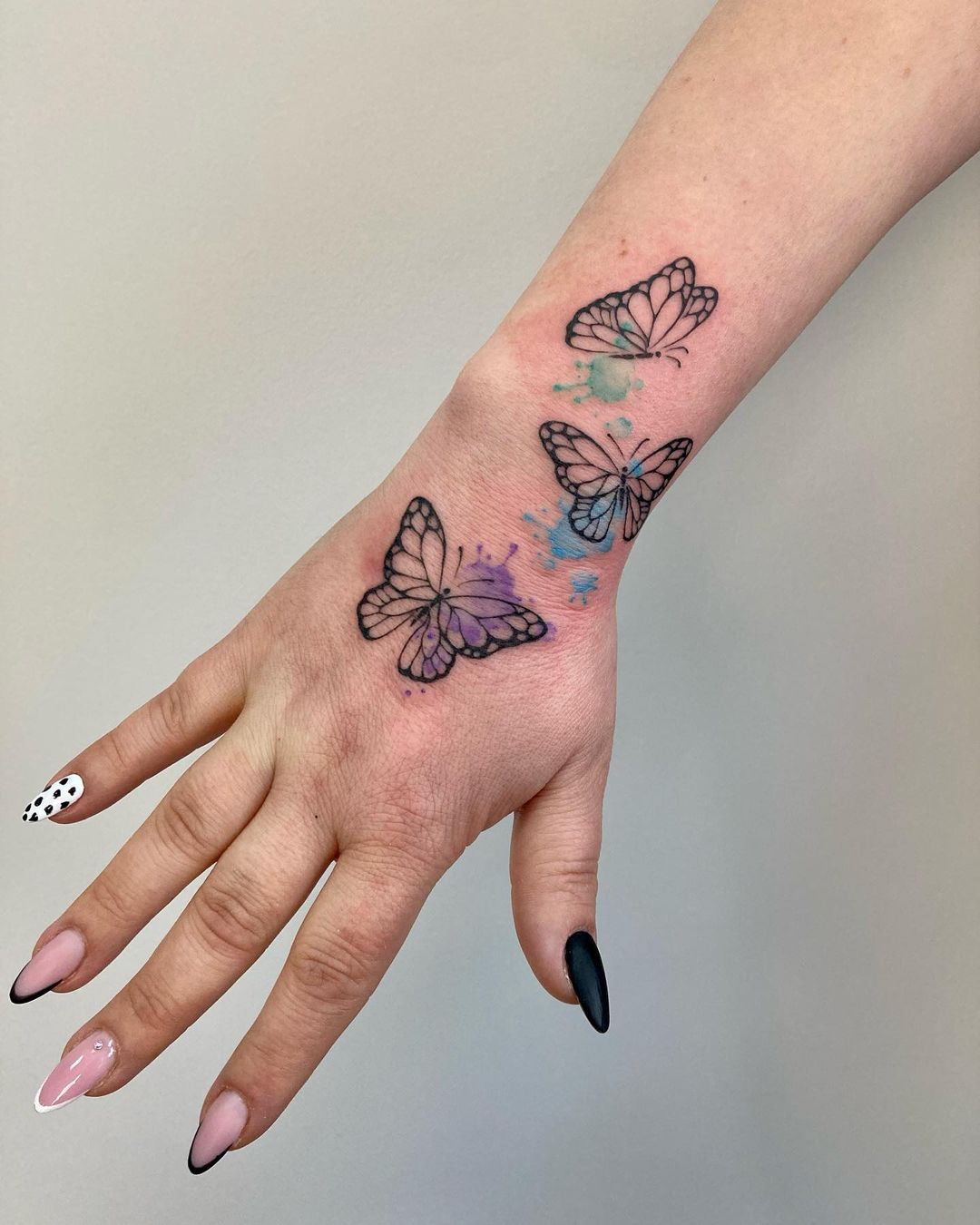 tatuaje de mariposas en la mano