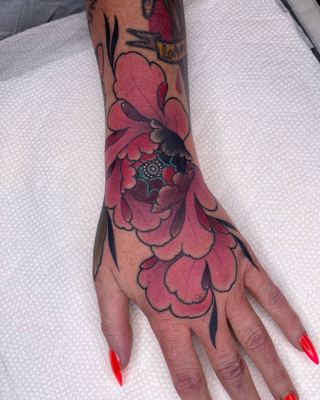 tatuagem de mão de flor colorida