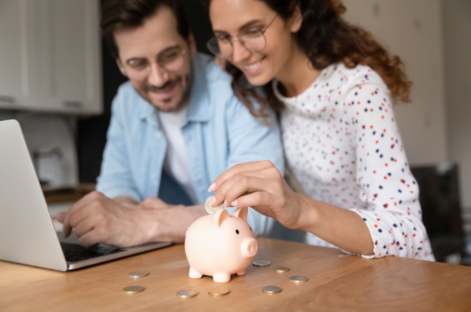 couple putting coins in a piggy bank