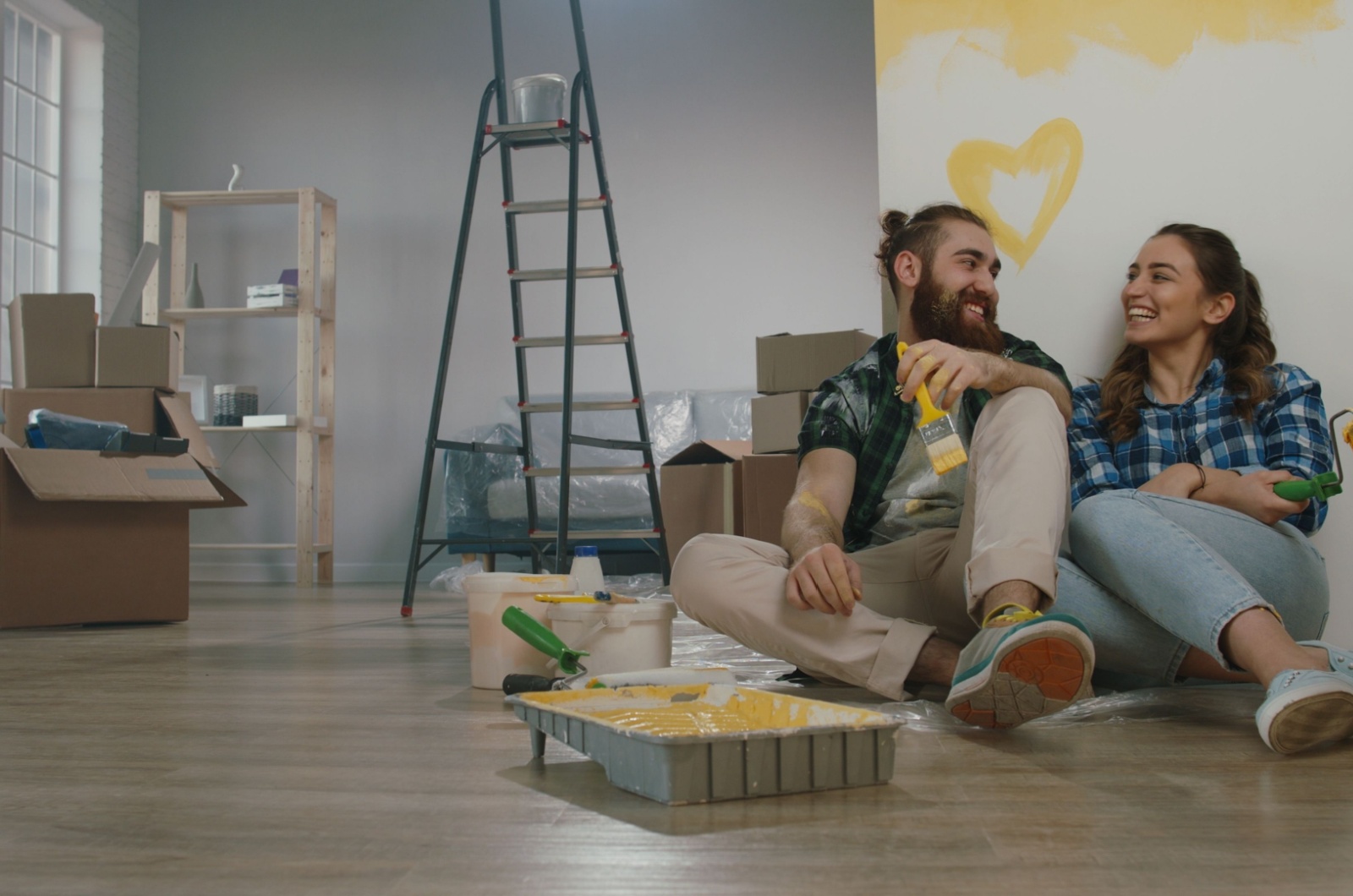 pareja sentada en el suelo con pintura