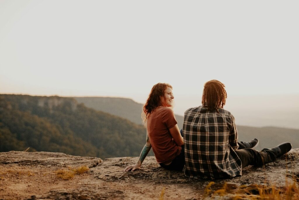 pareja hablando en la cima de la montaña