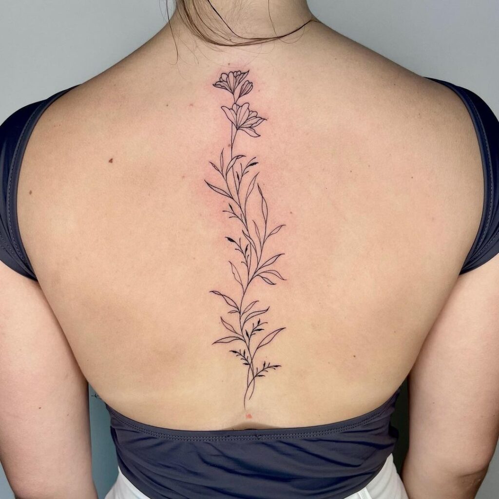 elegante tatuaje floral en la columna vertebral