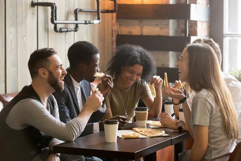 amici che ridono e mangiano insieme