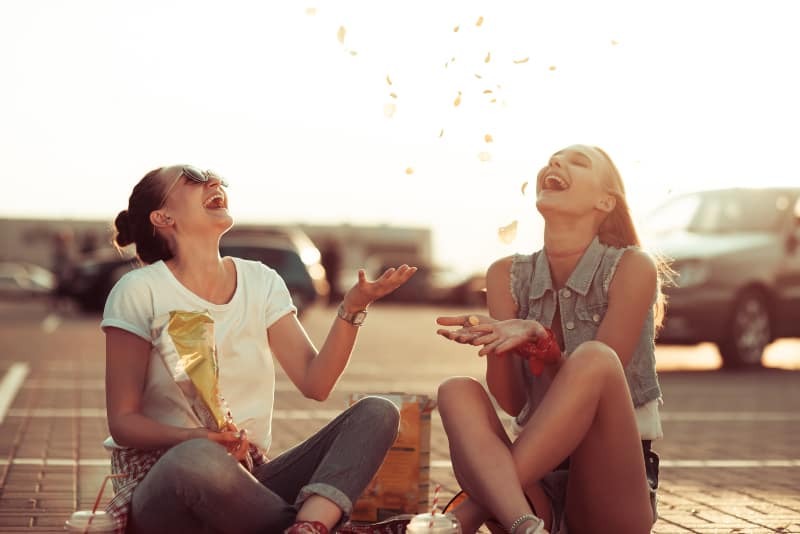 amigos felices sentados al aire libre en el suelo