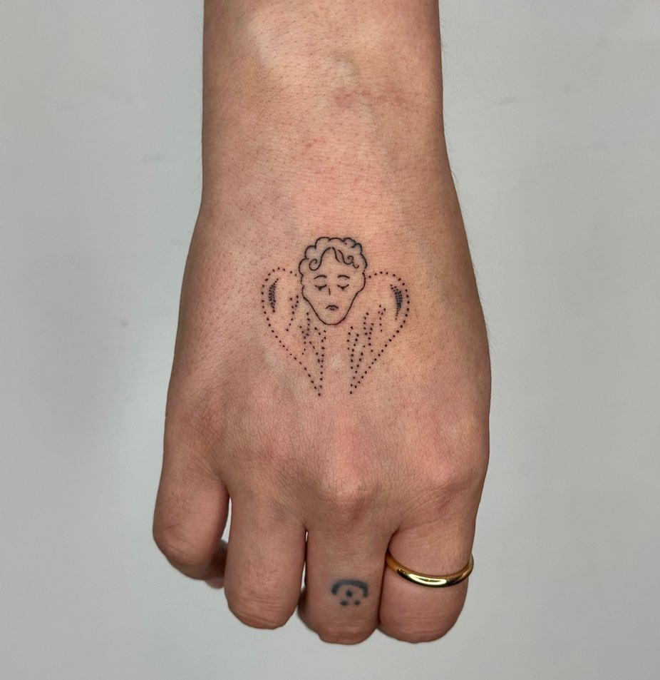 tatuaggio a mano con cuore e angelo