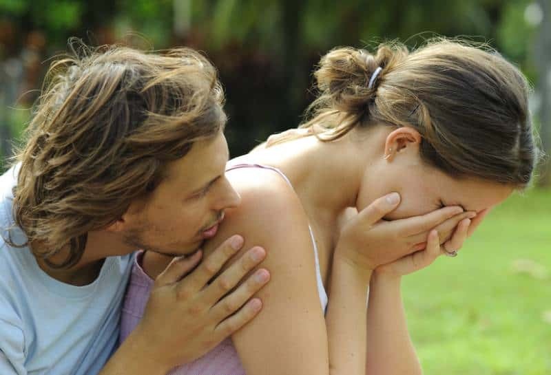 man comforting crying woman