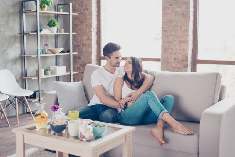 man hugging woman on the couch