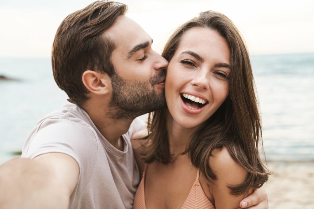 man kissing woman in cheek