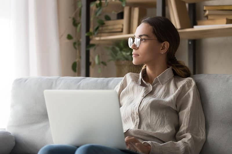 mulher atenta sentada com um computador portátil