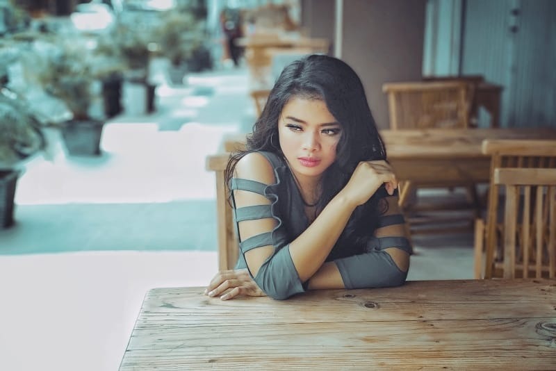 mujer triste sentada junto a una mesa