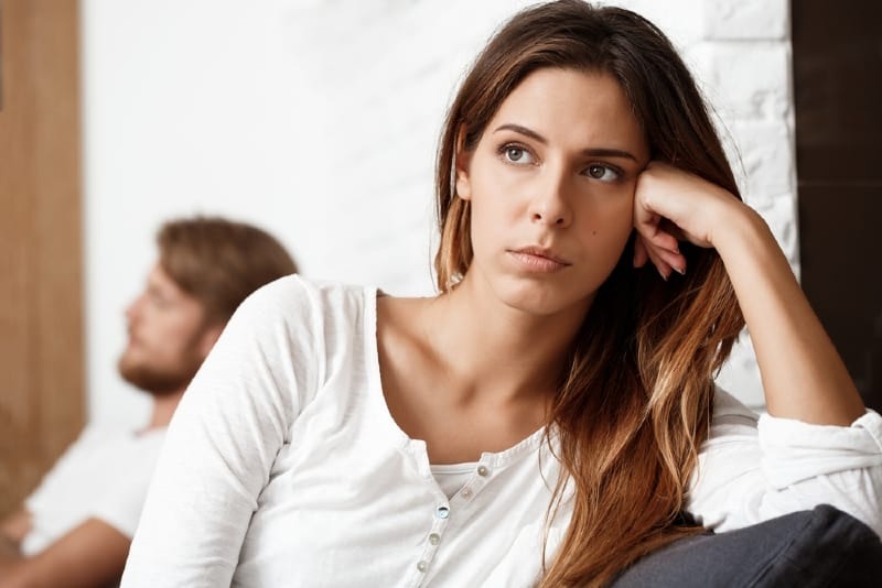 mujer triste sentada frente a un hombre