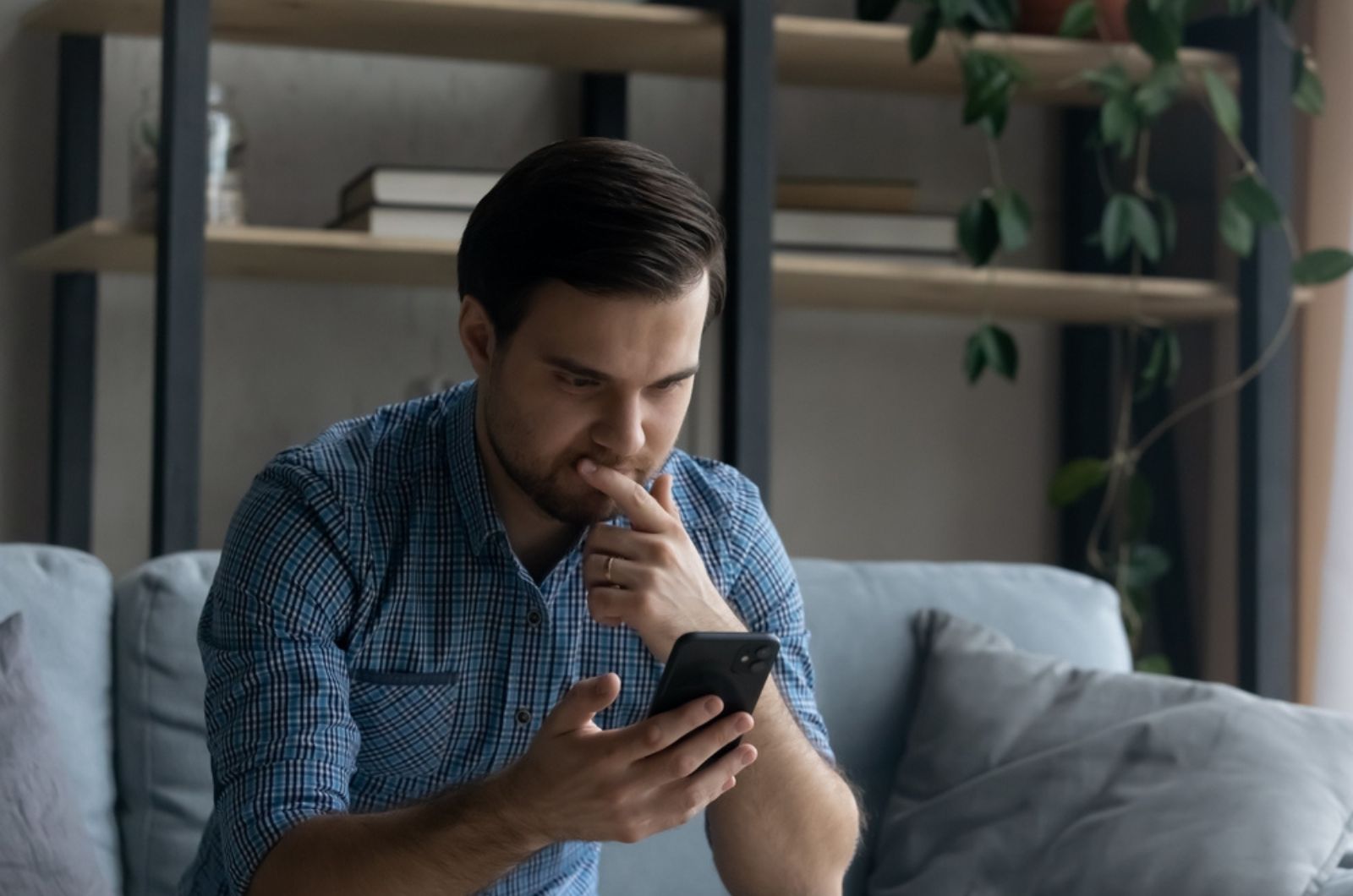 homem sério a olhar para o telemóvel