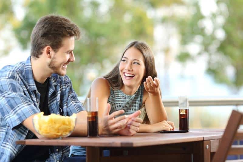 casal sorridente sentado num café