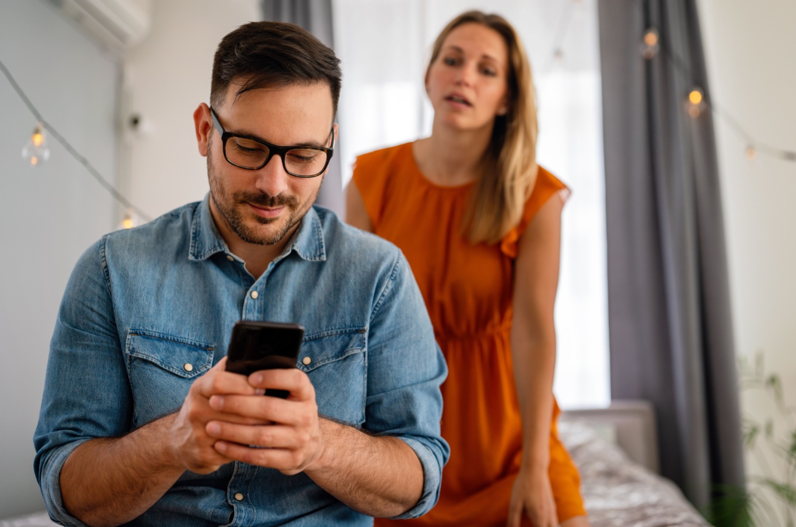 woman looking at boyfriend using his phone