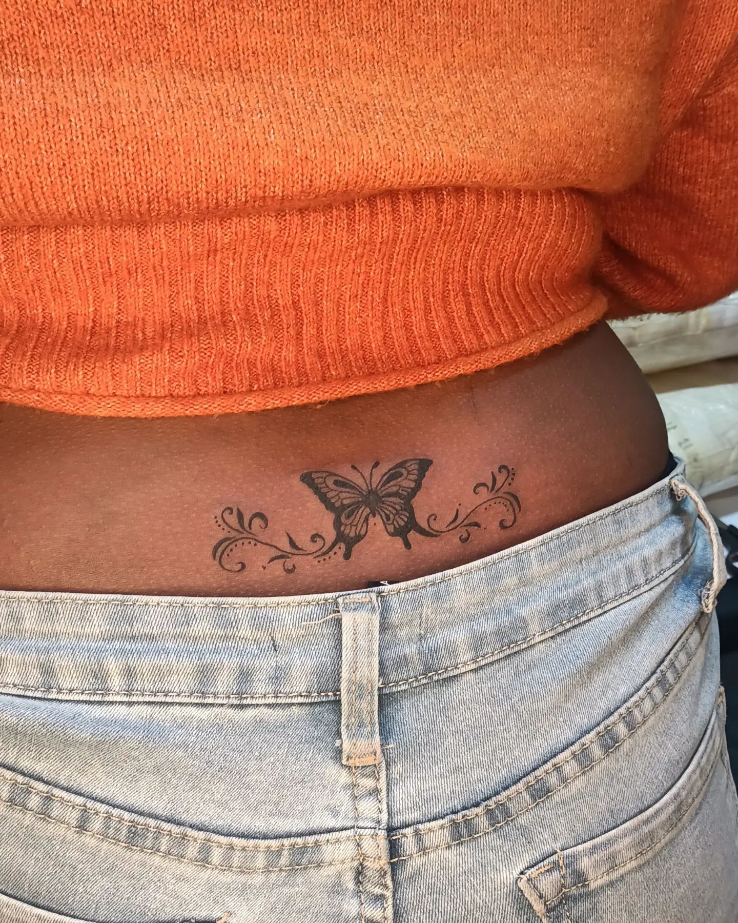 tatuagem de borboleta na parte inferior das costas