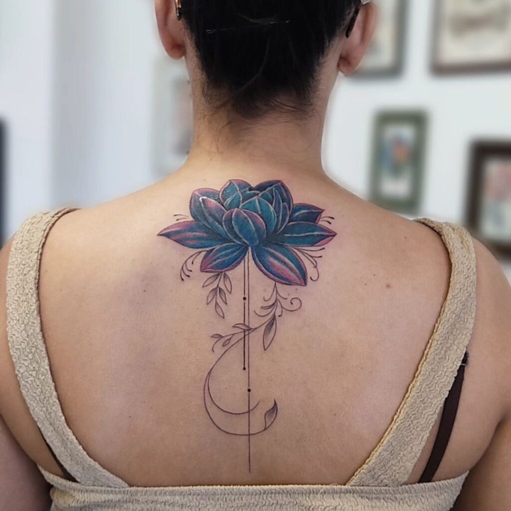 Tatuagem artística e colorida de lótus nas costas