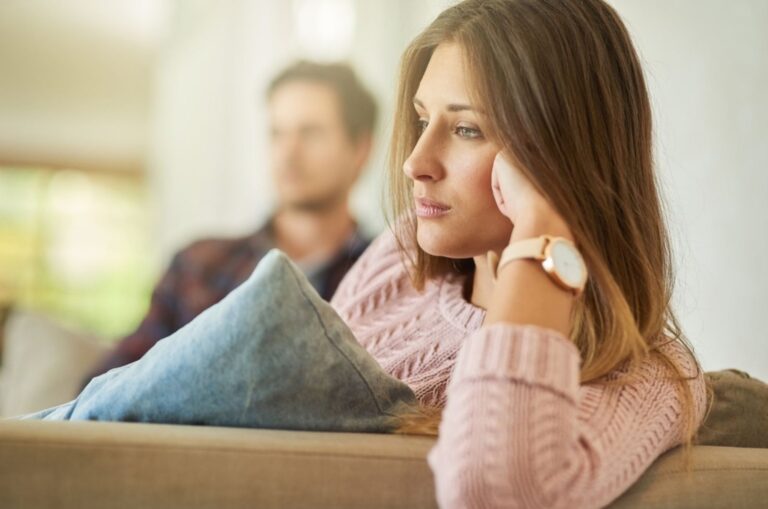 sad woman sitting away of her boyfriend