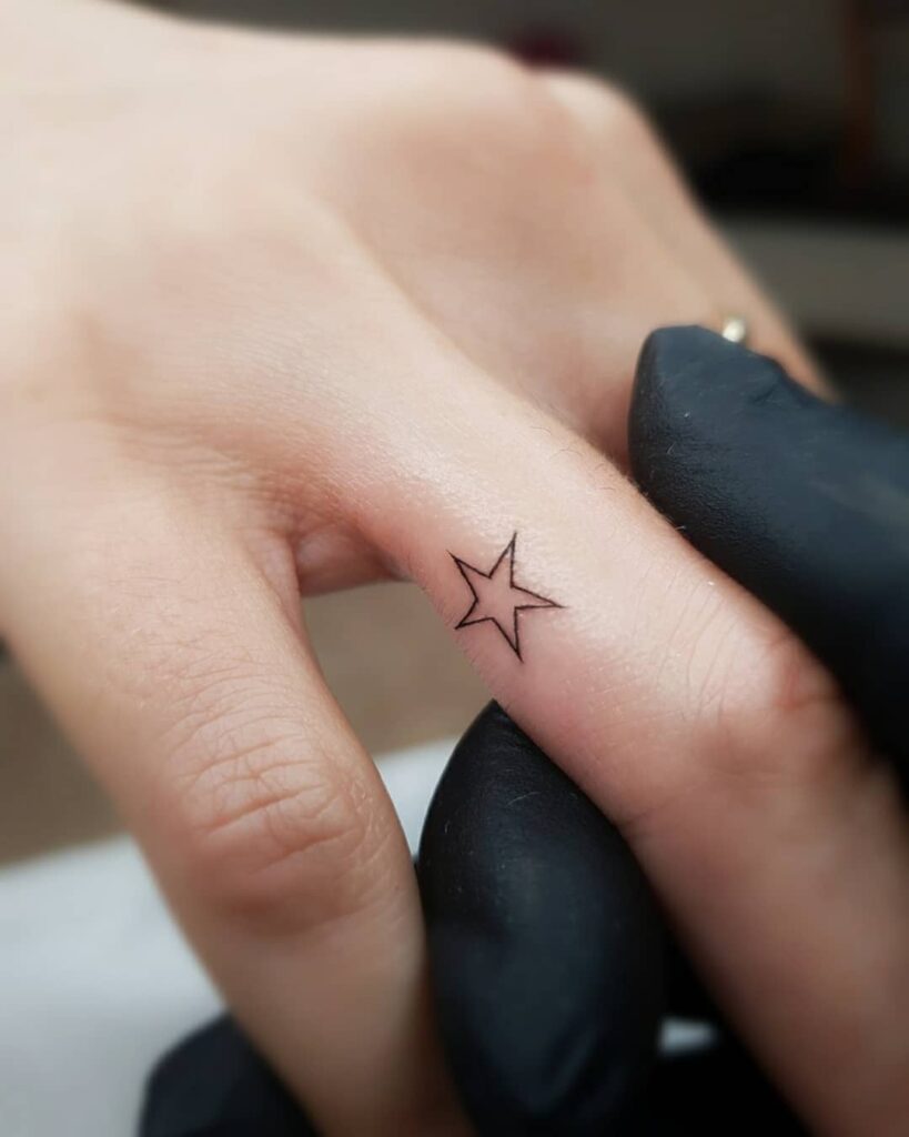 Tatuaggio a forma di stellina sul dito