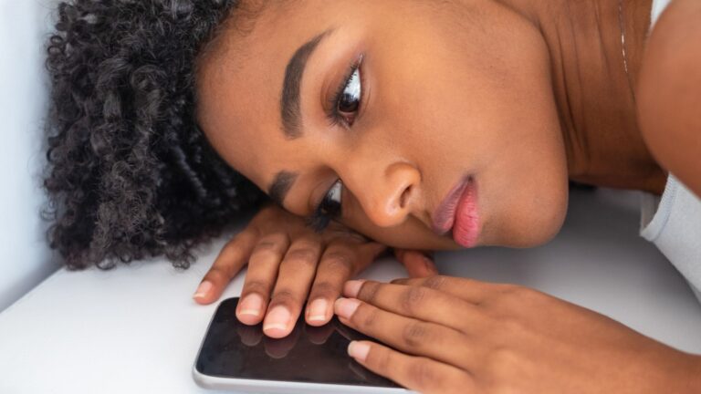 sad woman lying with her phone