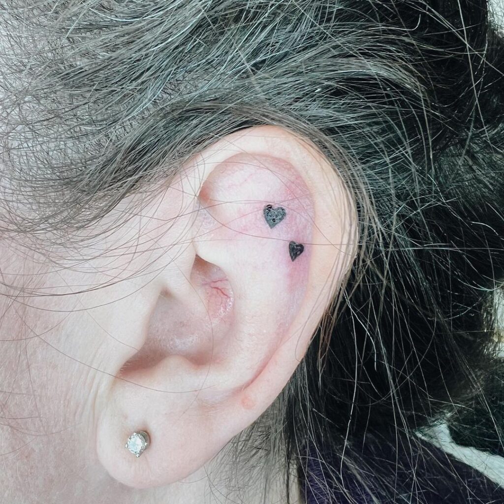 Tatuaje de microcorazones en la oreja