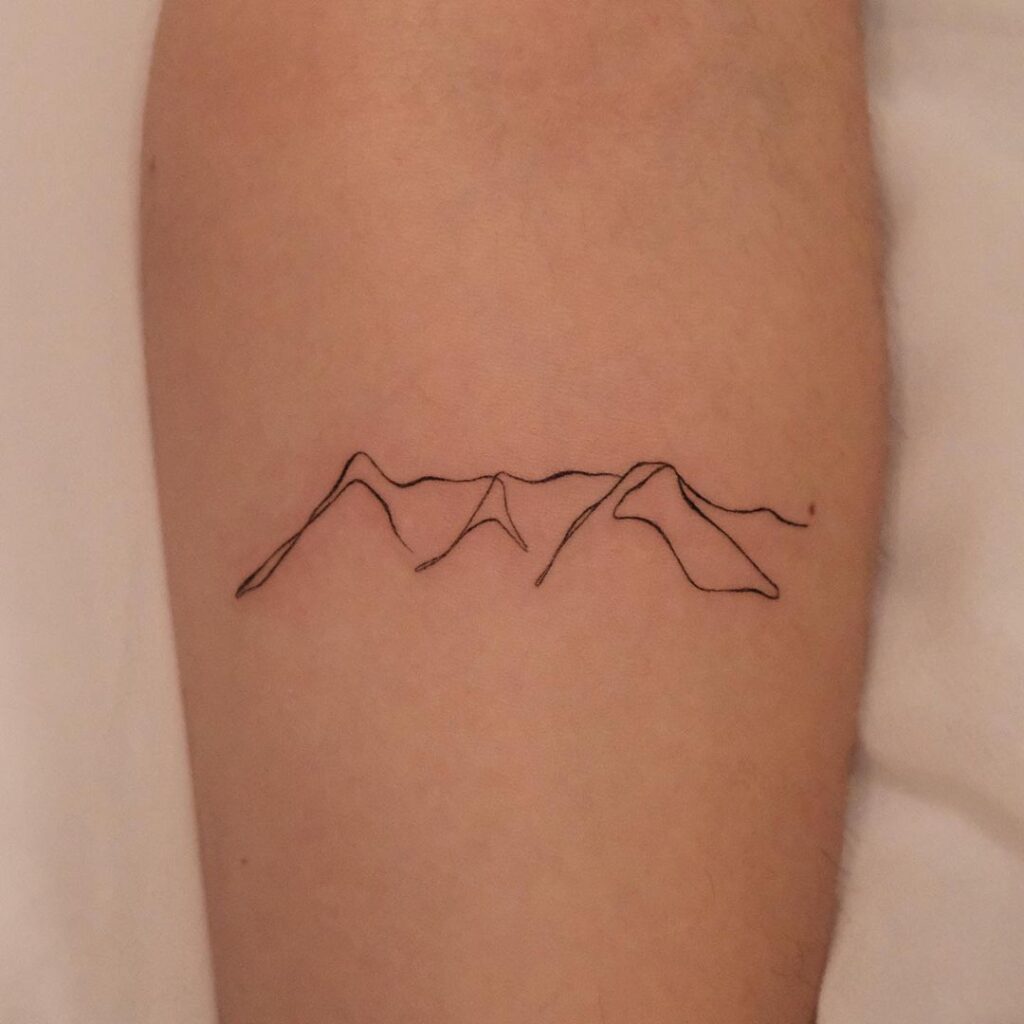 Tatuagem de uma linha sobre montanhas